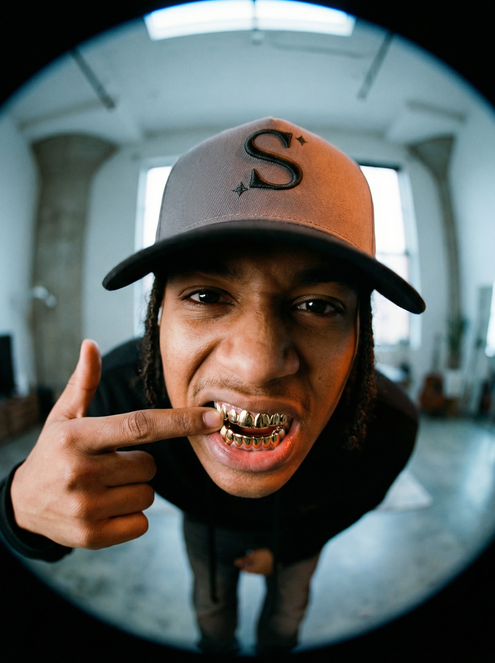 person wearing a grey trucker cap with a black 'S' logo