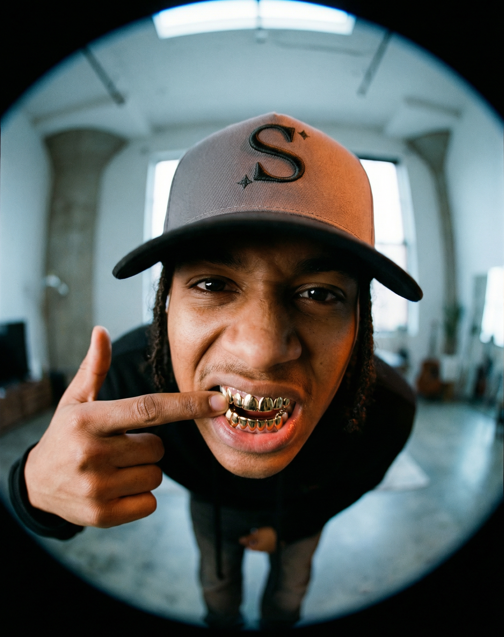 person wearing a grey trucker cap with a black 'S' logo