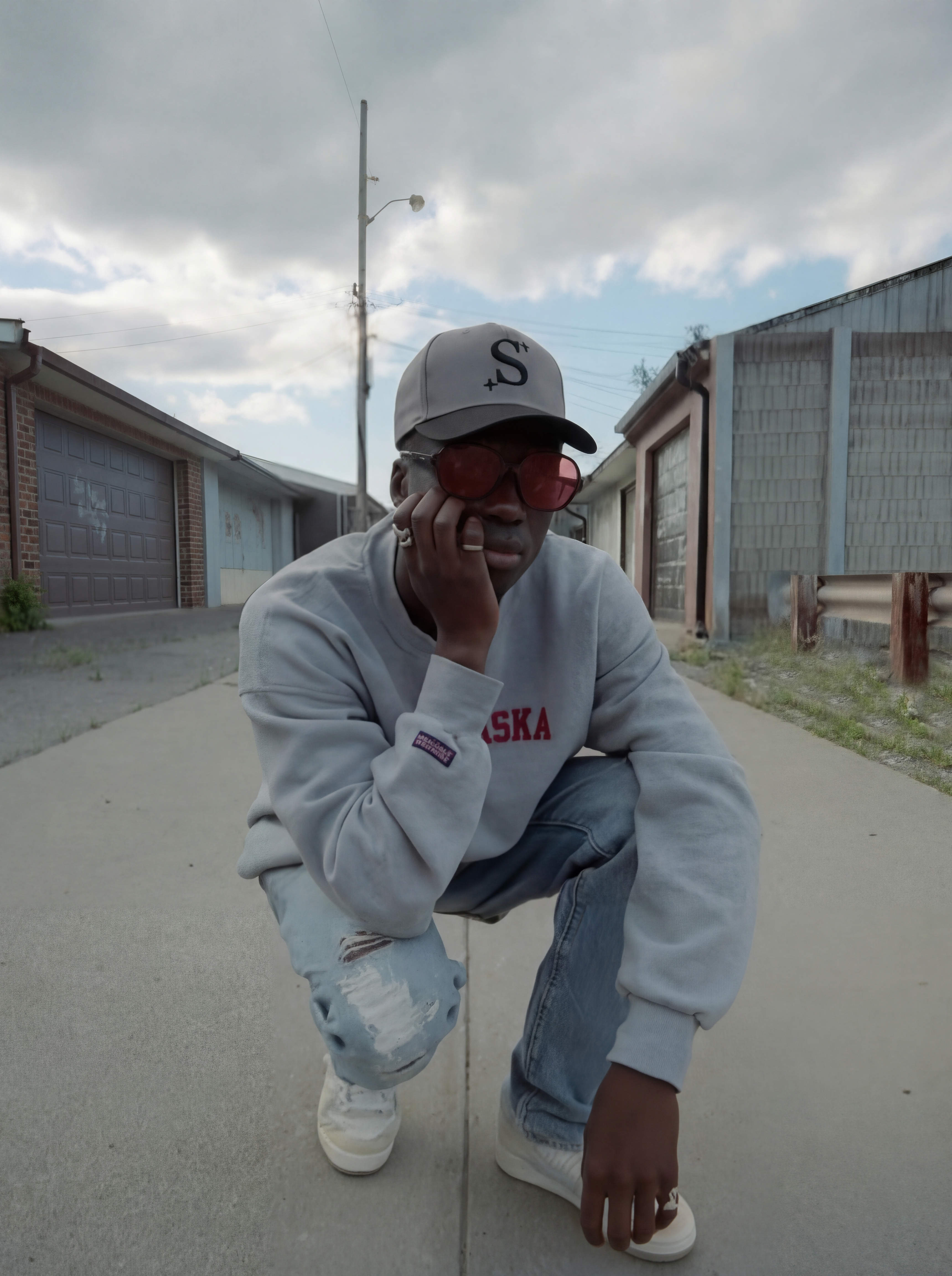 person wearing a grey trucker cap with a black 'S' logo