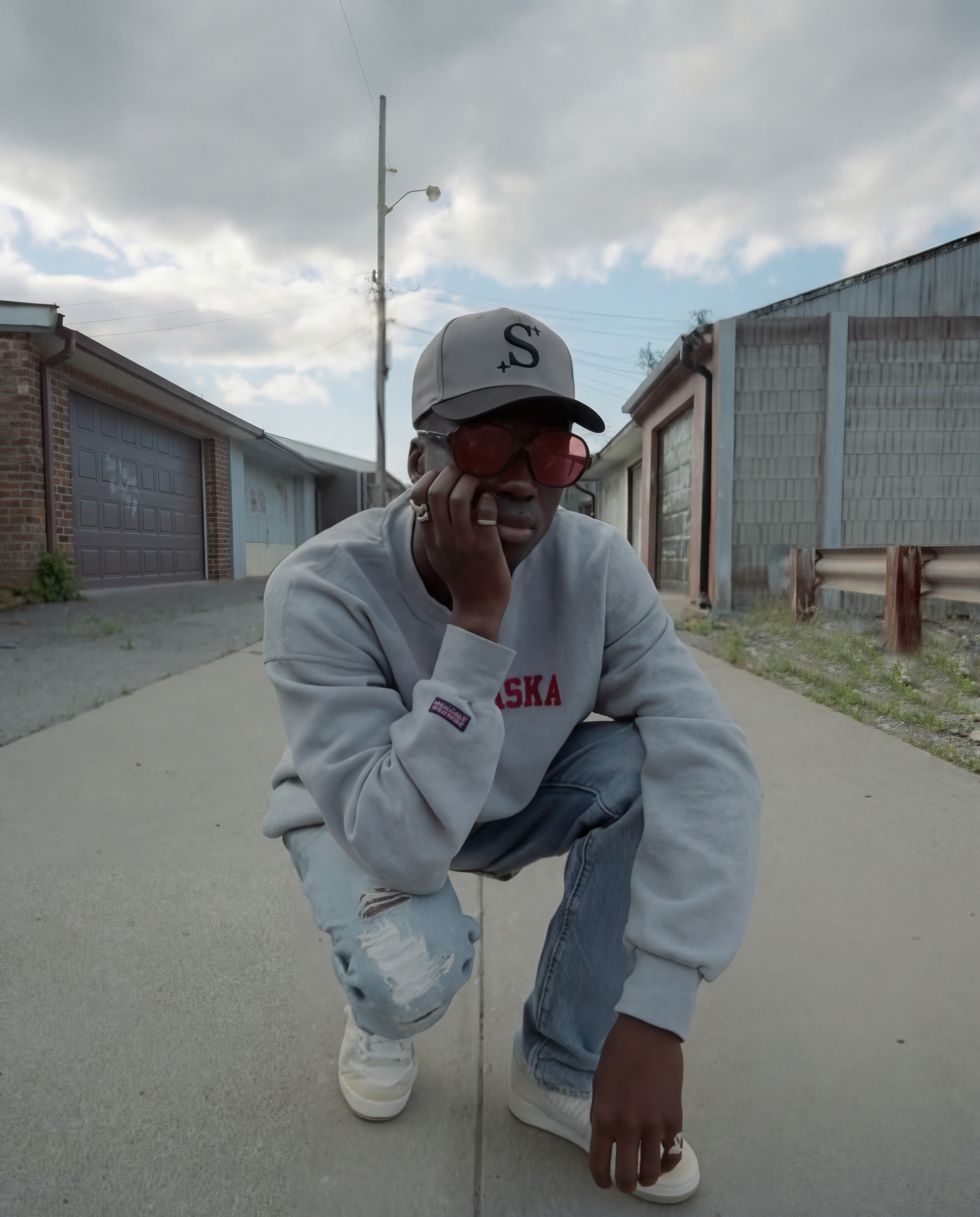 person wearing a grey trucker cap with a black 'S' logo